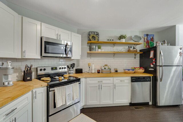 kitchen with wooden counters, stainless steel appliances, tasteful backsplash, white cabinets, and dark hardwood / wood-style flooring