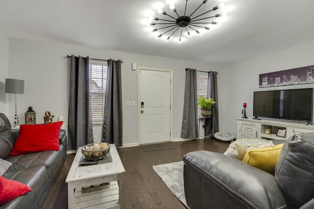 living room featuring an inviting chandelier and dark hardwood / wood-style flooring