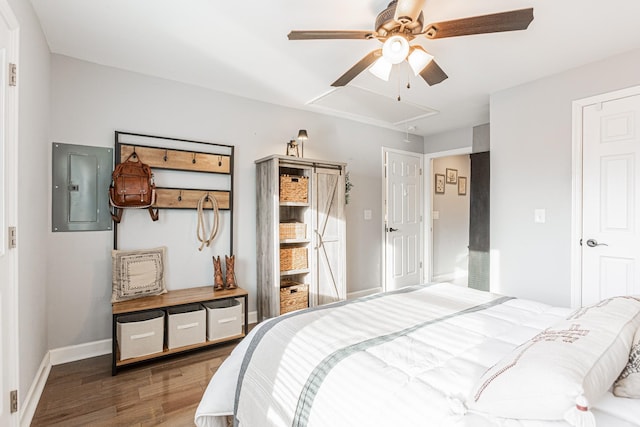 bedroom featuring ceiling fan, electric panel, and hardwood / wood-style floors