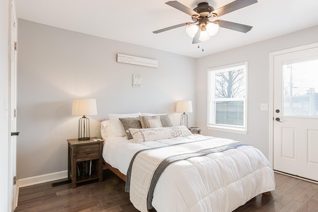 bedroom featuring multiple windows, dark wood-type flooring, and ceiling fan