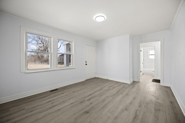 unfurnished room with crown molding and light hardwood / wood-style flooring