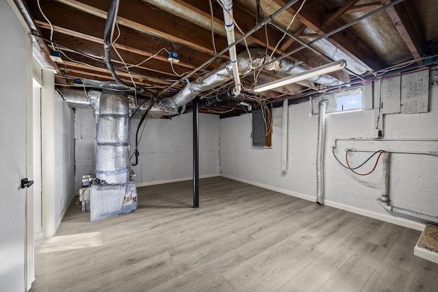 basement with hardwood / wood-style floors and electric panel