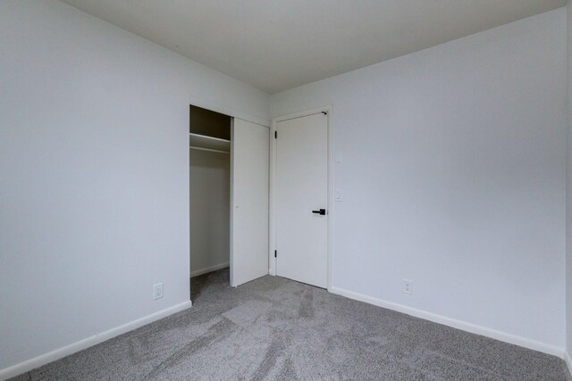 unfurnished bedroom featuring carpet floors and a closet