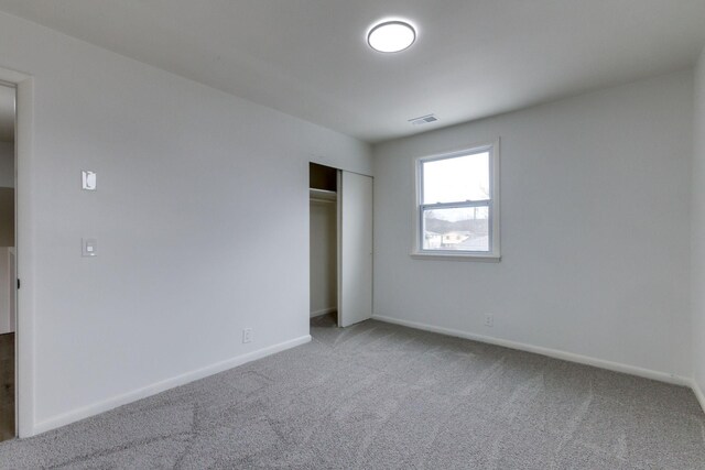 unfurnished bedroom featuring carpet flooring and a closet