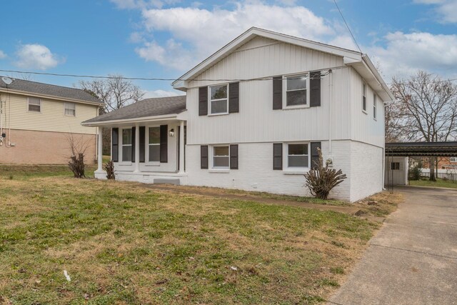 split level home featuring a porch, a carport, and a front lawn