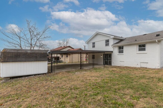 back of house featuring a carport, a storage shed, and a yard