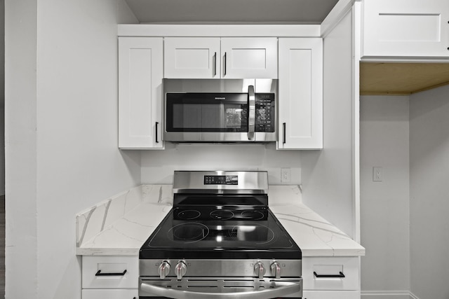 kitchen with white cabinetry, appliances with stainless steel finishes, and light stone countertops