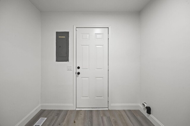 doorway with electric panel and light hardwood / wood-style floors