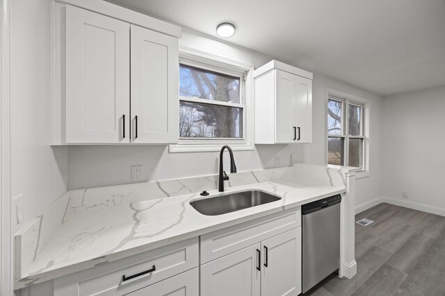 kitchen featuring white cabinetry, sink, light stone counters, and stainless steel dishwasher