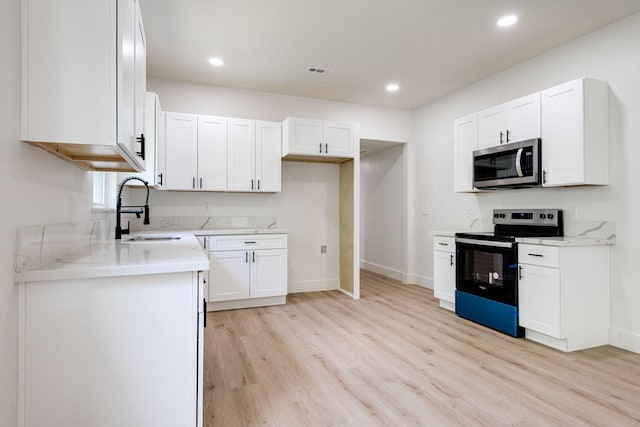 kitchen with white cabinetry, sink, electric range, light stone countertops, and light wood-type flooring