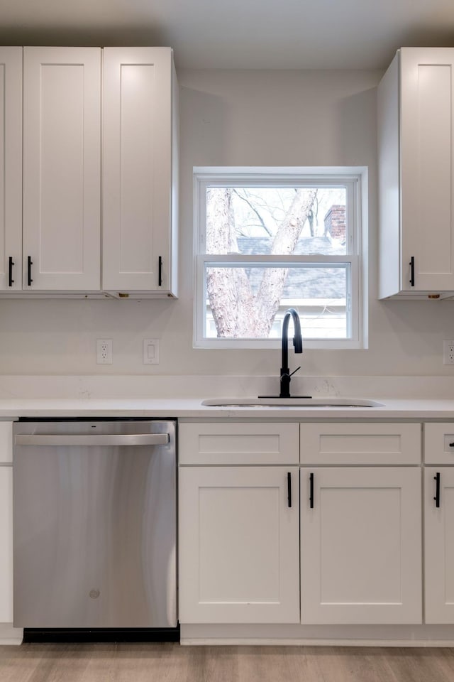 kitchen featuring white cabinetry, stainless steel dishwasher, and sink