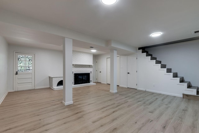 basement featuring a fireplace and light hardwood / wood-style flooring