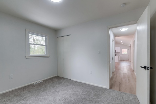 carpeted spare room featuring vaulted ceiling and a wealth of natural light