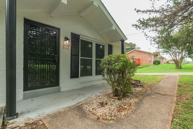 property entrance featuring a lawn