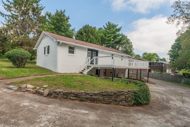 rear view of house with a wooden deck and a yard