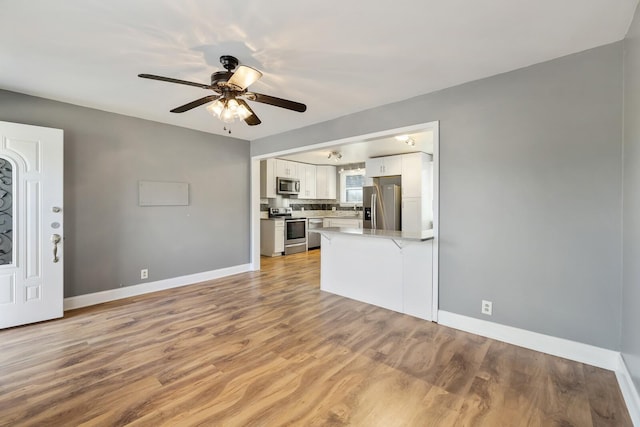 unfurnished living room featuring light hardwood / wood-style floors and ceiling fan