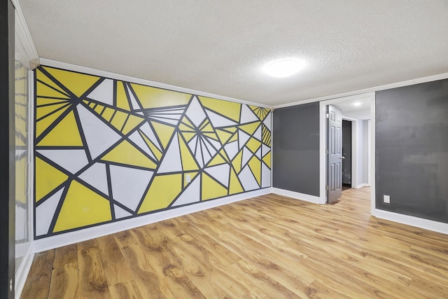 spare room featuring a textured ceiling and light hardwood / wood-style floors