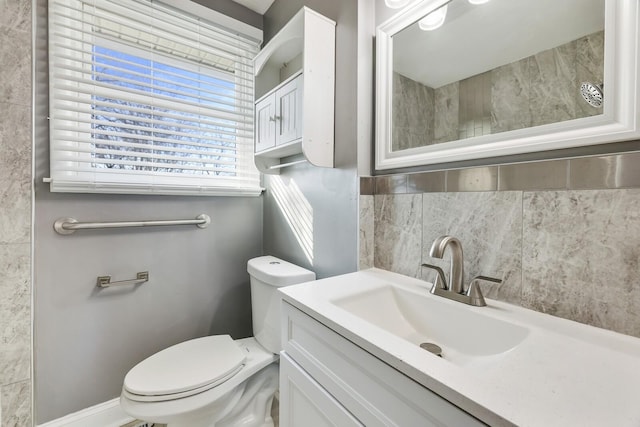 bathroom with vanity, toilet, and backsplash