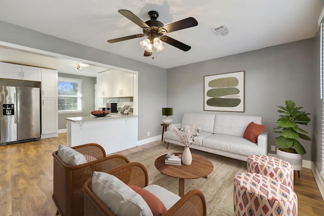 living room featuring ceiling fan and light hardwood / wood-style flooring