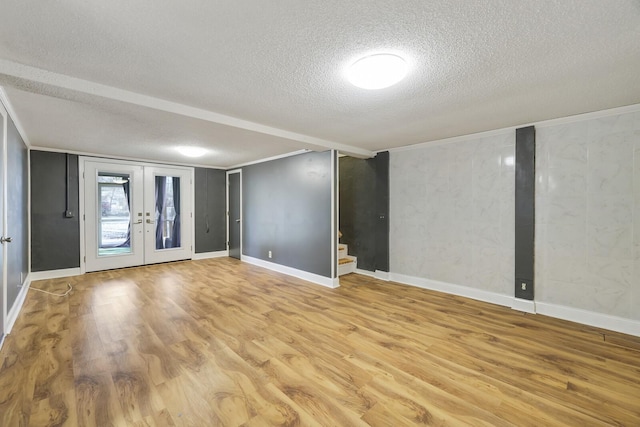 spare room with crown molding, hardwood / wood-style flooring, french doors, and a textured ceiling