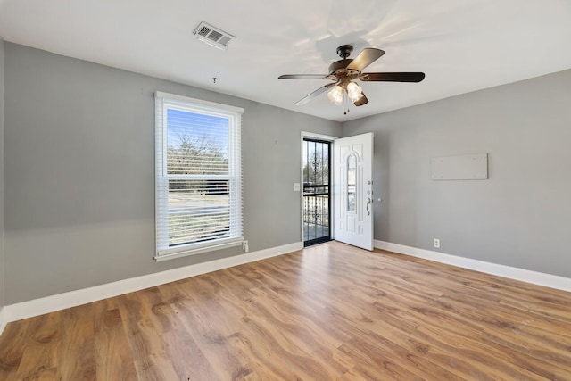 empty room with ceiling fan and light hardwood / wood-style floors