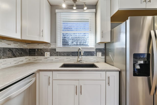 kitchen featuring white cabinetry, appliances with stainless steel finishes, sink, and tasteful backsplash