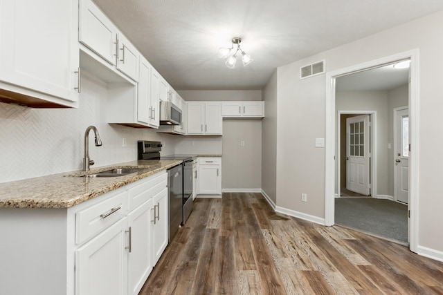 kitchen with white cabinetry, stainless steel range with electric stovetop, sink, and light stone counters