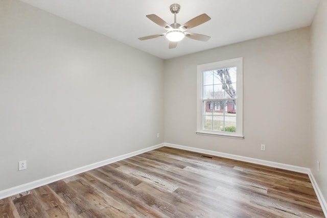 empty room with ceiling fan and light hardwood / wood-style flooring