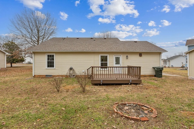 rear view of house featuring a yard, a deck, and an outdoor fire pit