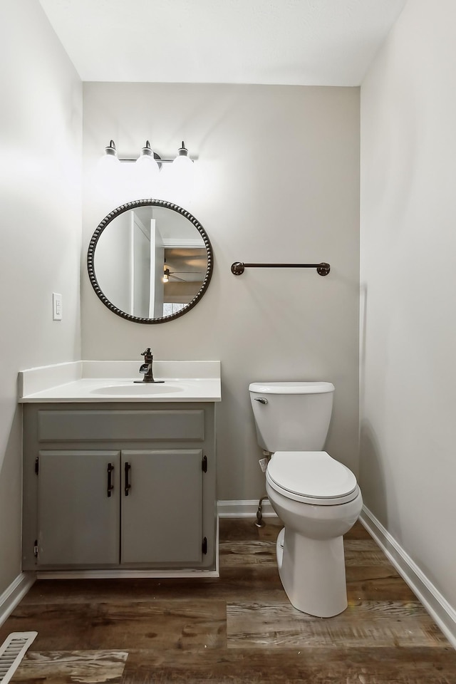 bathroom featuring vanity, hardwood / wood-style flooring, and toilet