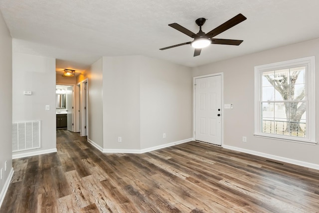 spare room with dark wood-type flooring and ceiling fan