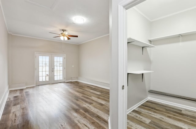 empty room with ornamental molding, hardwood / wood-style floors, ceiling fan, and french doors