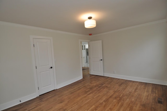 spare room featuring hardwood / wood-style flooring and ornamental molding