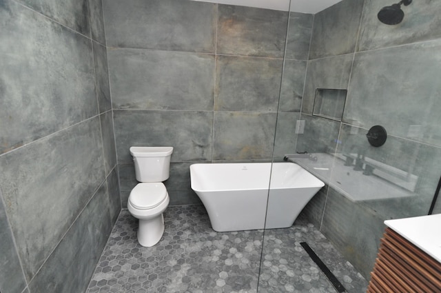 bathroom with tile patterned floors, toilet, a bathing tub, and tile walls