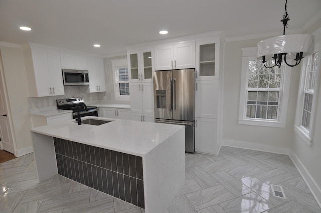 kitchen with stainless steel appliances, white cabinetry, a center island with sink, and pendant lighting