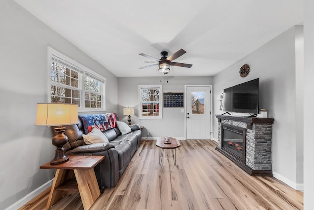 living room featuring ceiling fan, wood-type flooring, and a fireplace