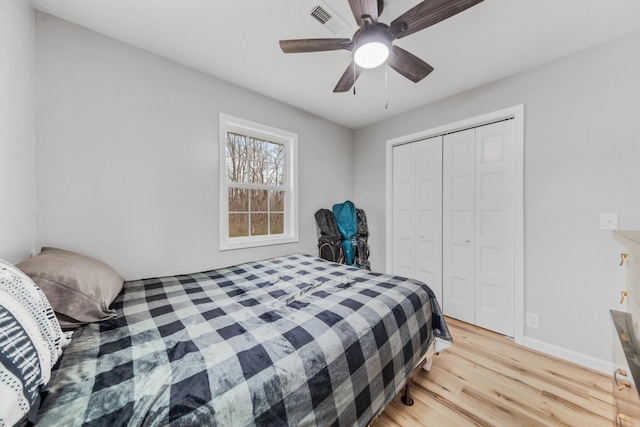 bedroom with ceiling fan, a closet, and light hardwood / wood-style flooring