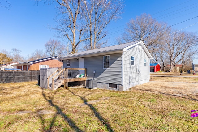 back of property featuring a wooden deck, a yard, and cooling unit