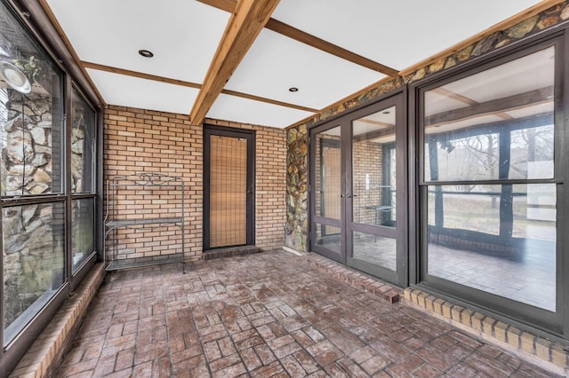 unfurnished sunroom with beam ceiling