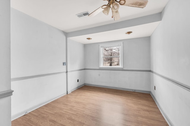 empty room with ceiling fan and light hardwood / wood-style flooring