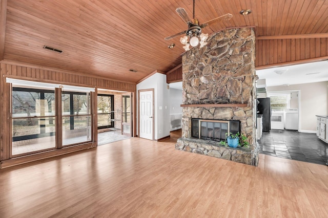 unfurnished living room featuring vaulted ceiling, a stone fireplace, wood-type flooring, ceiling fan, and wooden ceiling