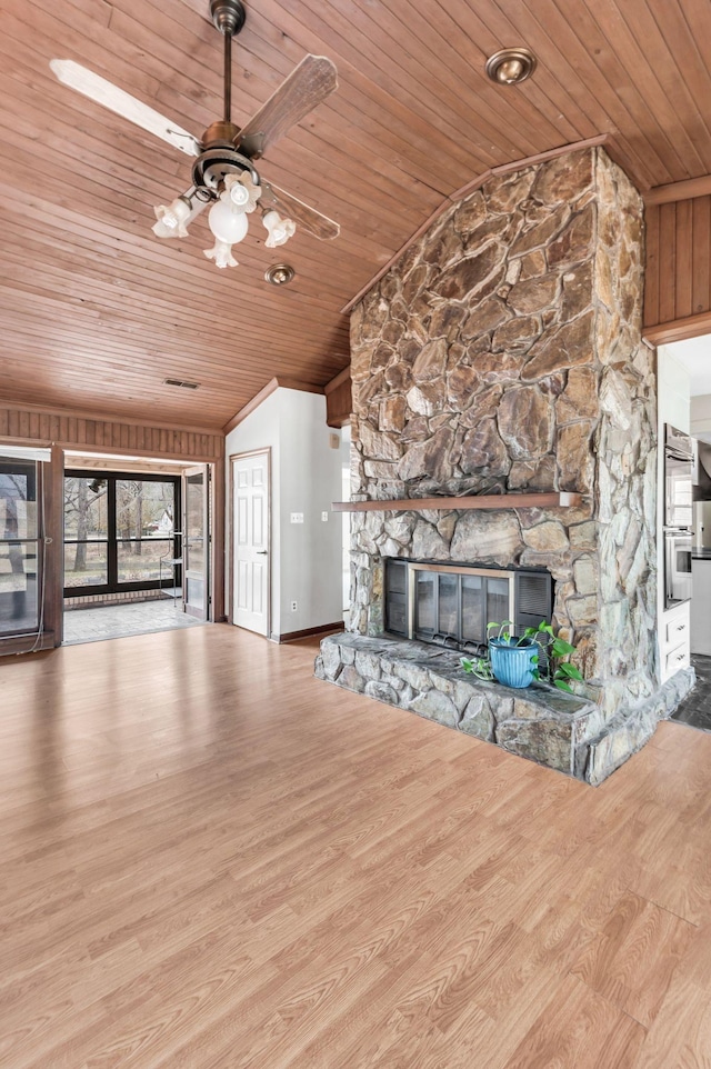 unfurnished living room featuring wood ceiling, lofted ceiling, a fireplace, and light hardwood / wood-style floors