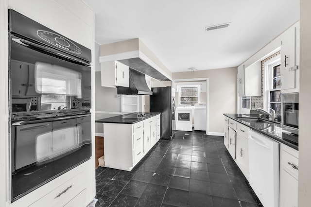 kitchen with sink, white cabinetry, tasteful backsplash, black appliances, and washing machine and clothes dryer