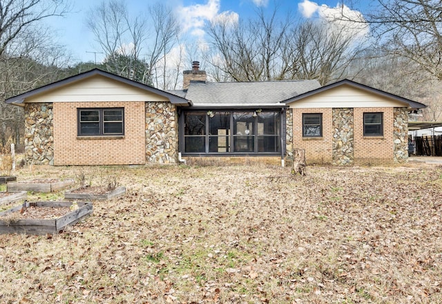 rear view of property featuring a sunroom