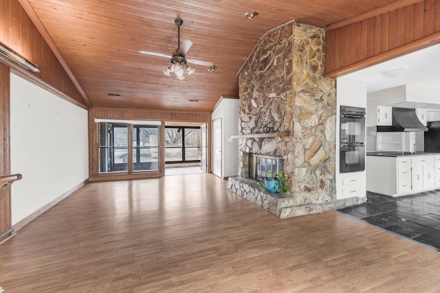 unfurnished living room featuring hardwood / wood-style flooring, ceiling fan, a fireplace, vaulted ceiling, and wooden ceiling