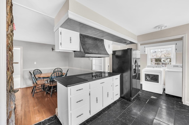 kitchen featuring white cabinetry, wall chimney exhaust hood, separate washer and dryer, and black appliances