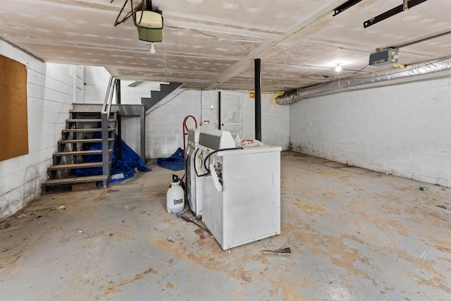 unfinished below grade area featuring stairway, washer / clothes dryer, and concrete block wall