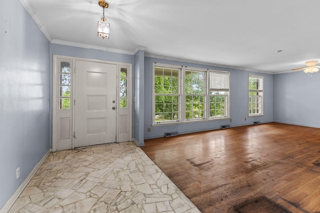 foyer with ornamental molding, baseboards, a ceiling fan, and visible vents
