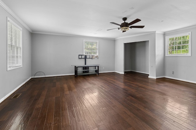 interior space with ornamental molding, baseboards, a ceiling fan, and dark wood finished floors