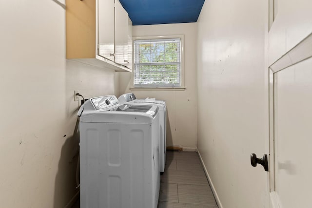laundry area with cabinet space, baseboards, and washer and dryer